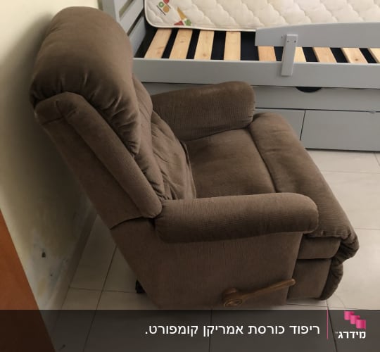 כורסה מרופדת חומה ליד מיטה עם מזרן